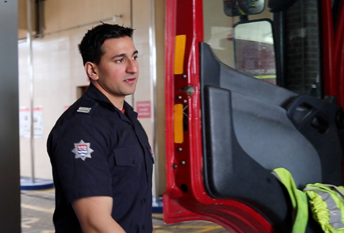Firefighter Raja walking towards the door of a fire engine