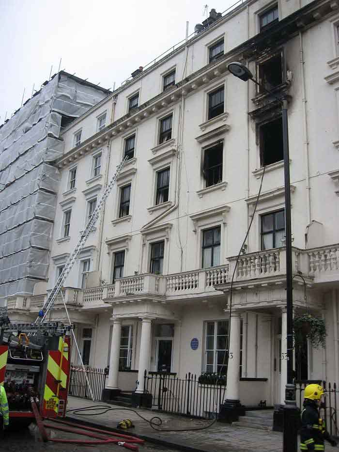 Fire engine at the scene of an incident with a ladder by the building window