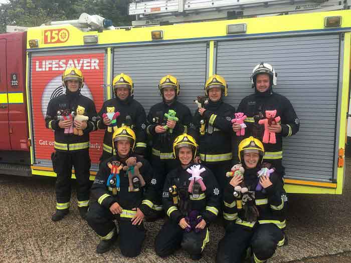 Firefighters from Hillingdon holding the trauma bears next to a fire engine 