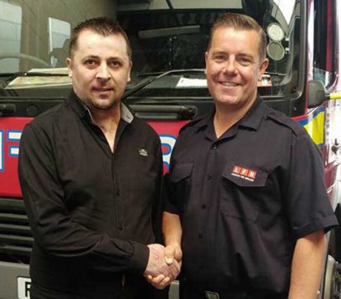 Fire rescue victim standing with Firefigher in front of fire engine 