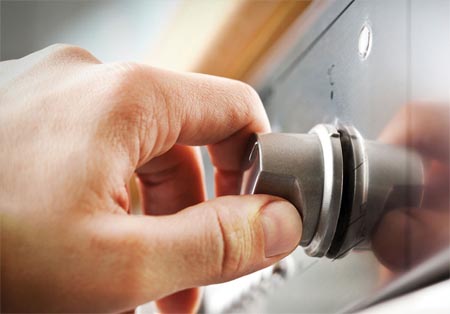 Hand turning a stove control knob 
