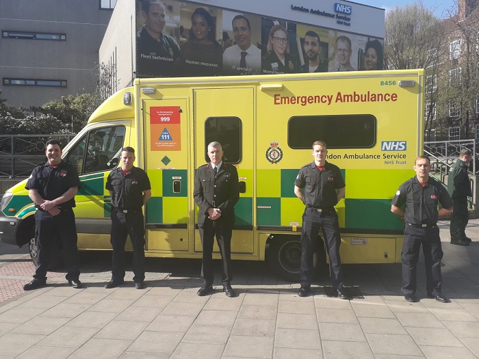 Commissioner Andy Roe and firefighters standing in front of an ambulance