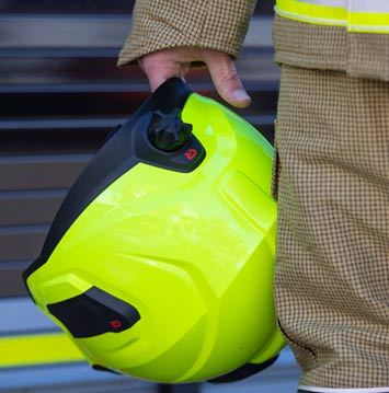 A firefighter holding a helmet.