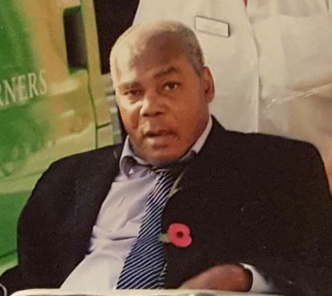 Cedric Skyers wearing a black suit sitting in a wheelchair