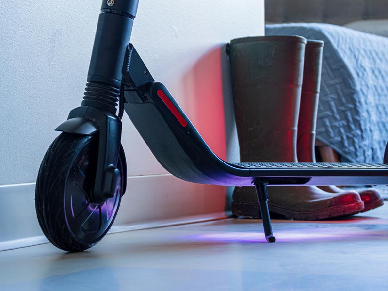 An e-scooter charging in a bedroom.