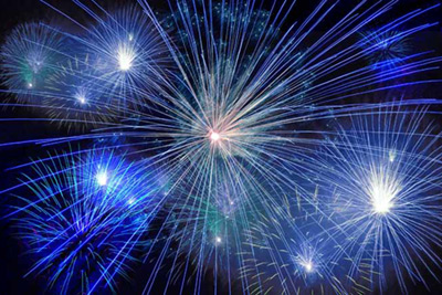 Blue, green and white fireworks in a dark sky.