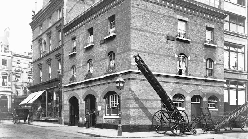 Exterior of the previous Kensington Fire Stations. It is located on the corner of two streets and two wheeled escape fire ladders are stored to one side of the building.