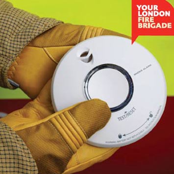 A firefighter holding a smoke alarm.