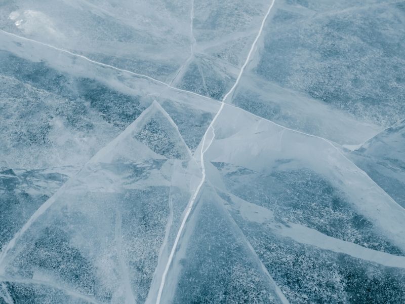 A sheet of cracked ice above water.