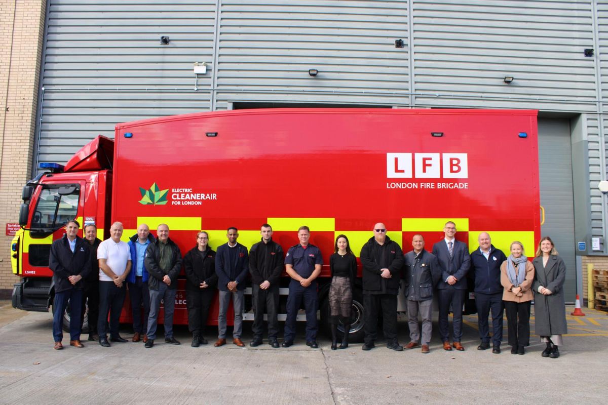 Sixteen members of LFB, Babcock and Renault staff standing in a line in front of the electric operational support centre lorry