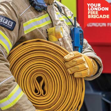 A firefighter carrying a hose.