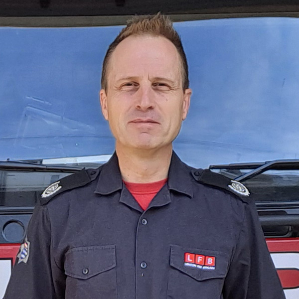 Borough Commander Graeme Hunter standing in front of a fire engine.