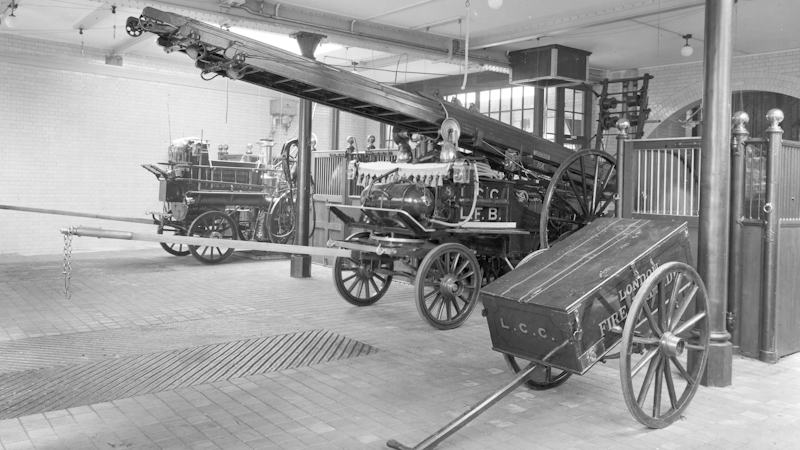 Two fire engines and a fire hose cart are stored in the appliance bay of Kensington Fire Station, ready for use in around 1907.