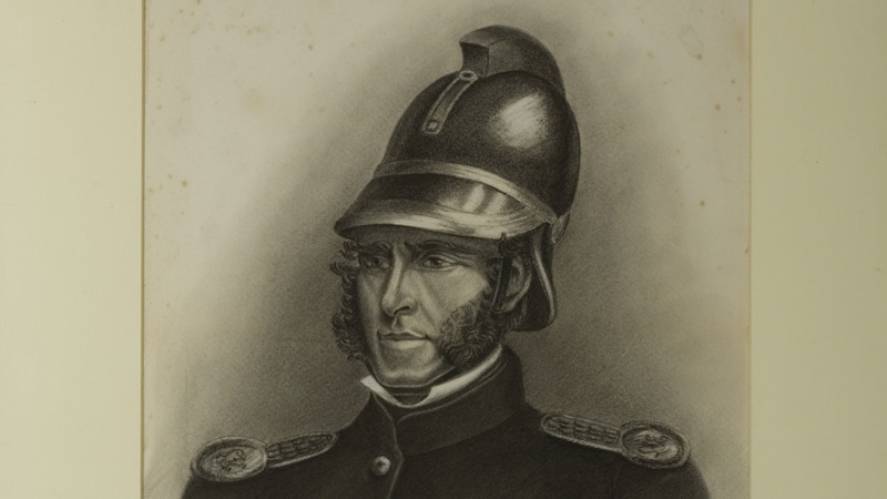 James Braidwood smartly dressed in his uniform, wearing shiny epaulettes on his shoulders and a polished black fire helmet