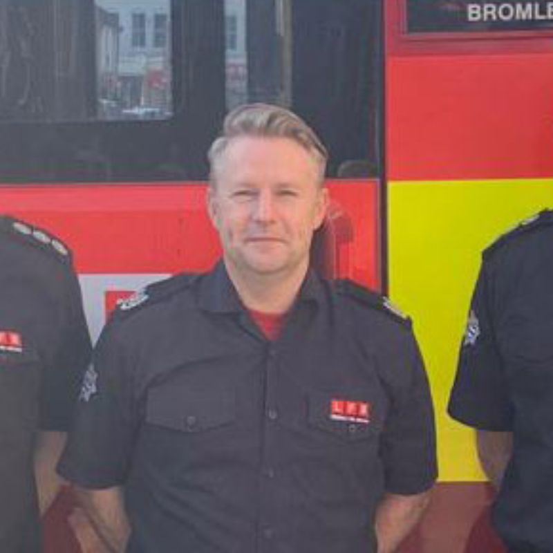 Ian Frame standing in front of a fire engine.